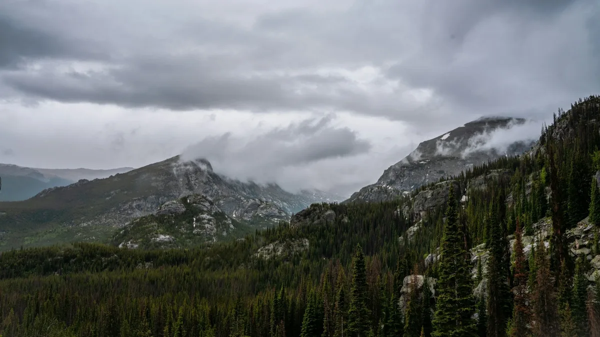 Low clouds crossing a layered mountain landscape