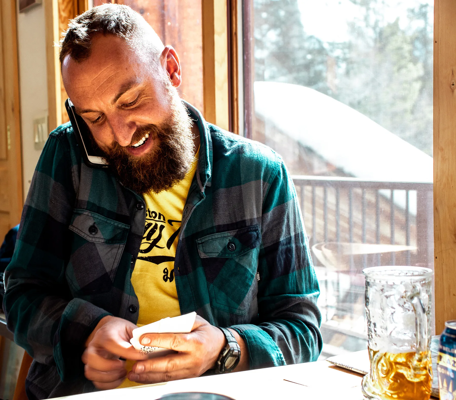 Aaron Hutten laughing during a phone call at a table